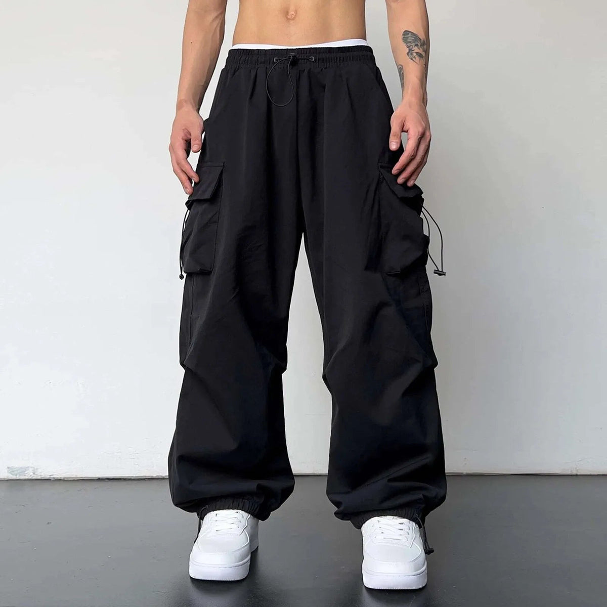 Men's wide-leg cargo trousers with a drawcord waist, flap pockets and adjustable ankles - black