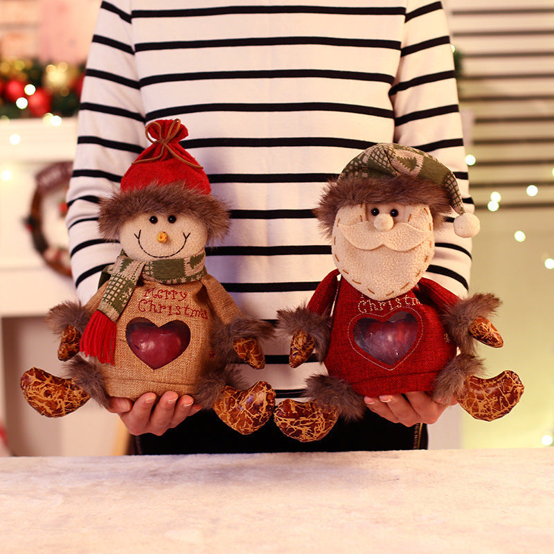 Seated plush Christmas figure with hat, scarf and a heart-shaped window in the body