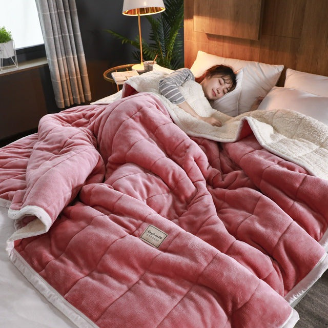 Quilted flannel fleece blanket with a sherpa reverse on a bed - rose red