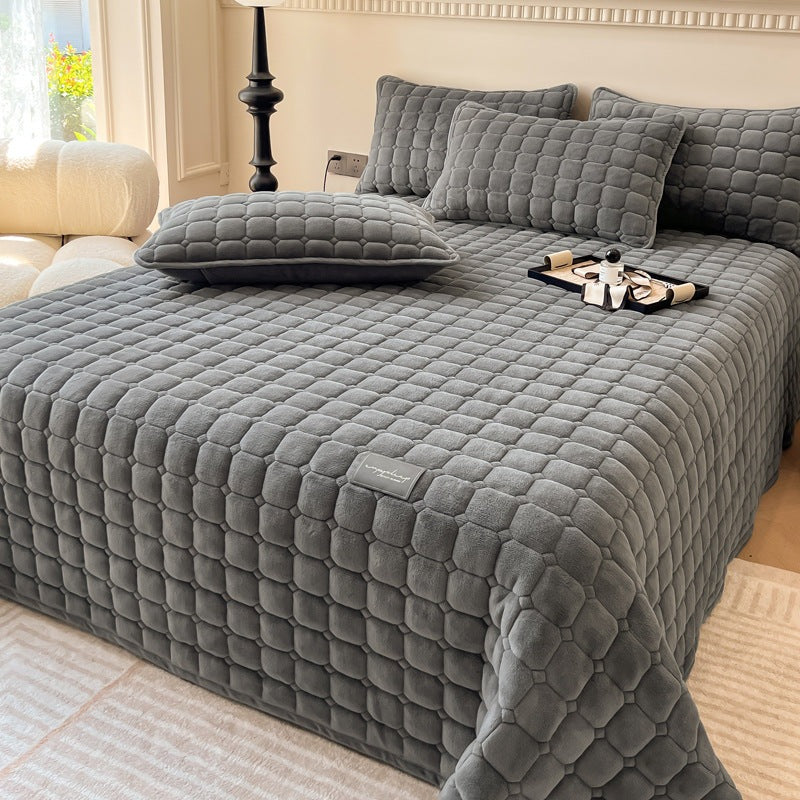 Quilted teddy bedspread with a square pattern on a double bed - dark grey