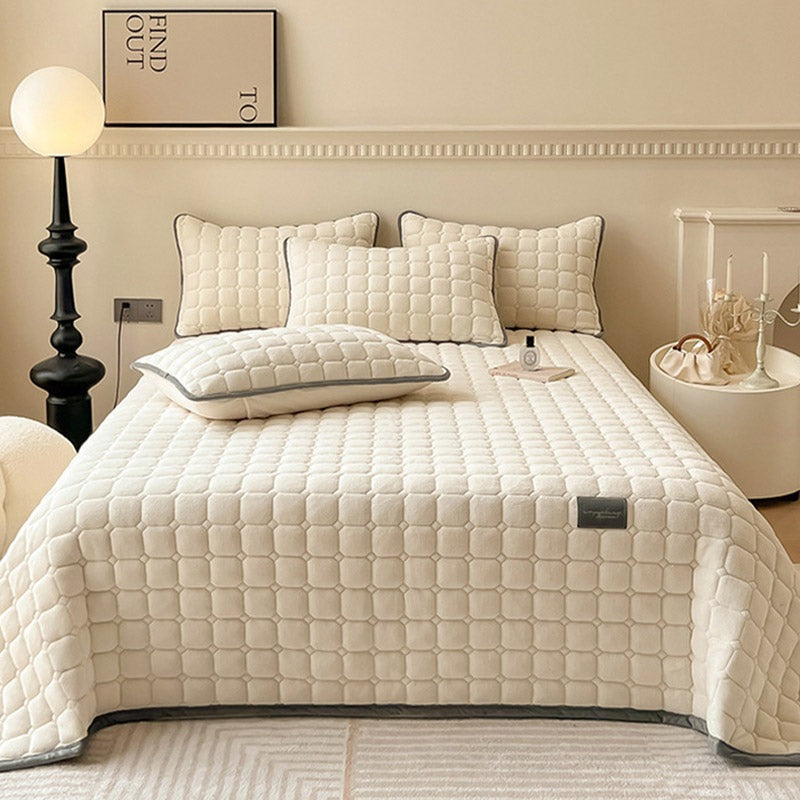 Quilted teddy bedspread with a square pattern on a double bed - cream