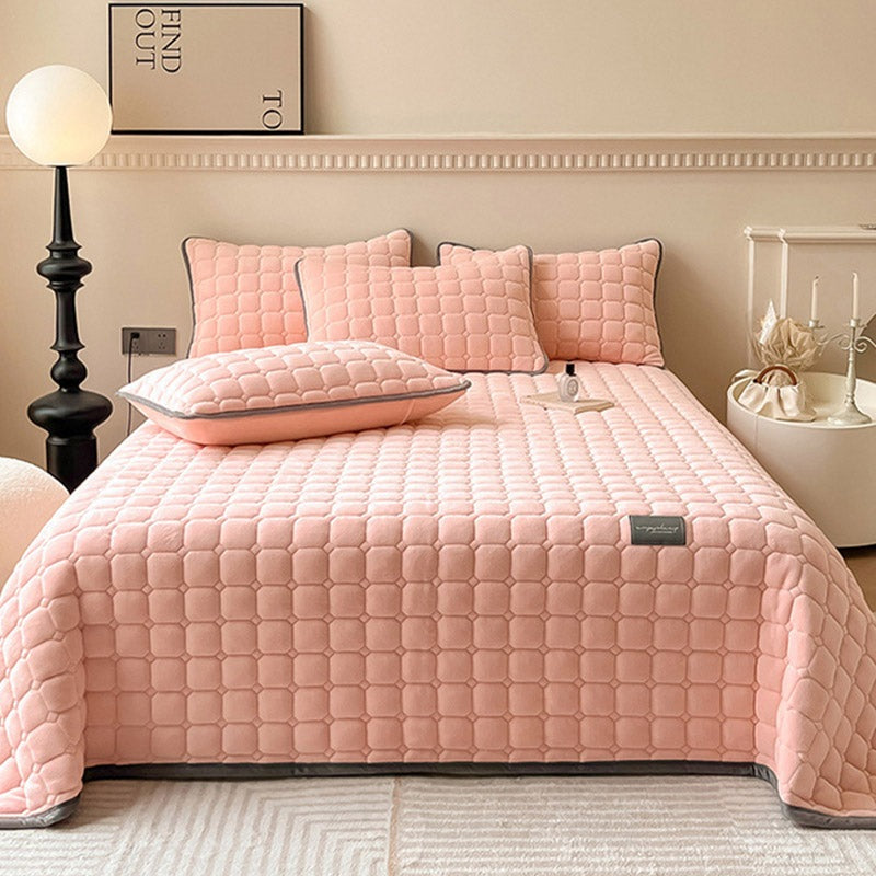 Quilted teddy bedspread with a square pattern on a double bed - pink