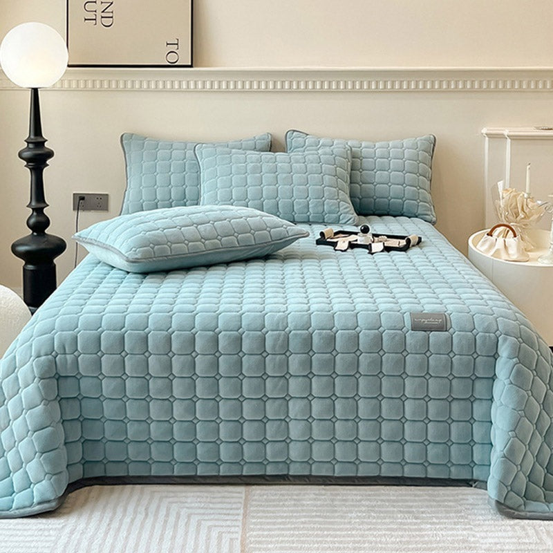 Quilted teddy bedspread with a square pattern on a double bed - light blue