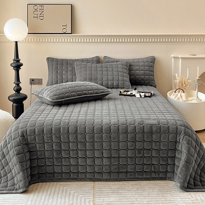 Quilted teddy bedspread with a square pattern on a double bed - dark grey