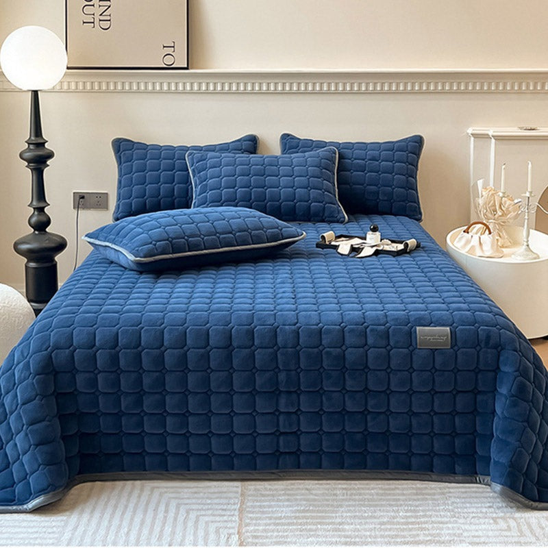 Quilted teddy bedspread with a square pattern on a double bed - dark blue