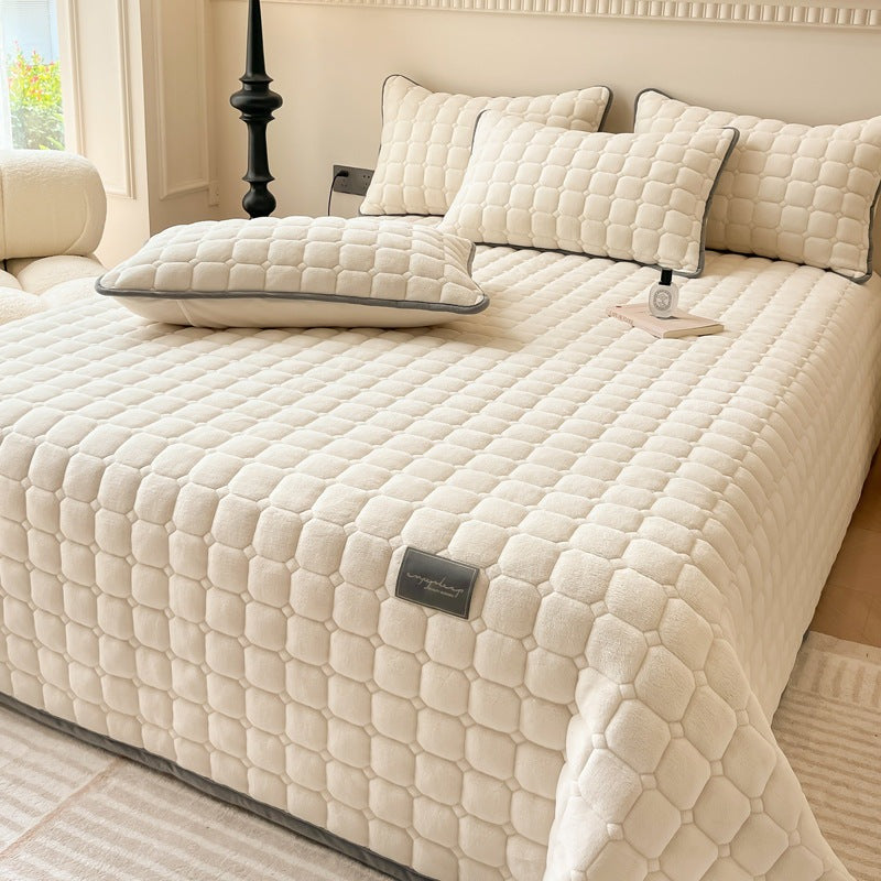 Quilted teddy bedspread with a square pattern on a double bed - cream