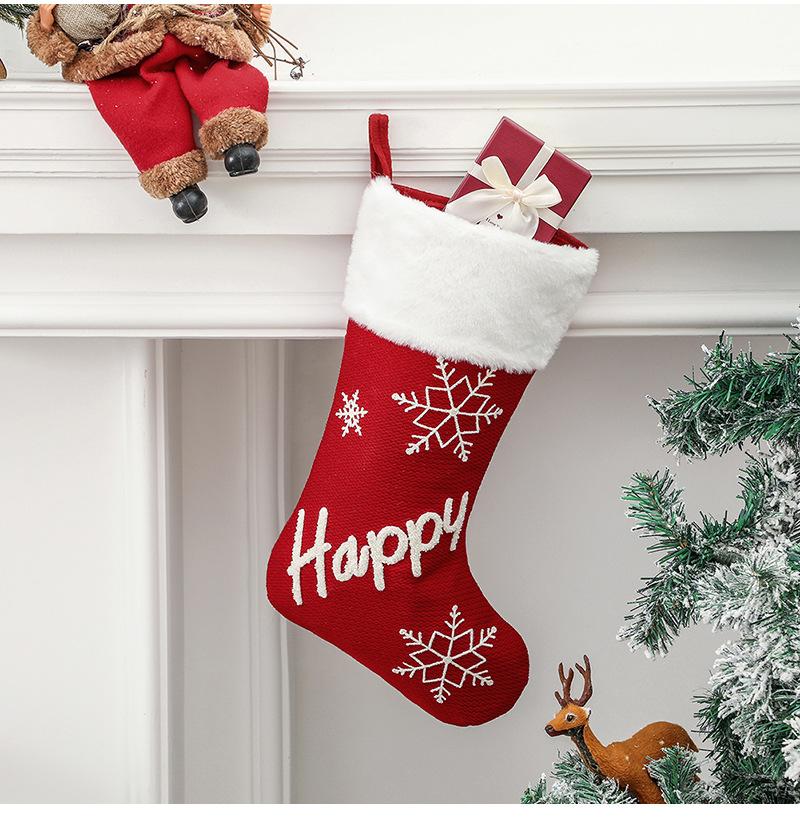 Red Christmas stocking with a white plush cuff, snowflakes and lettering