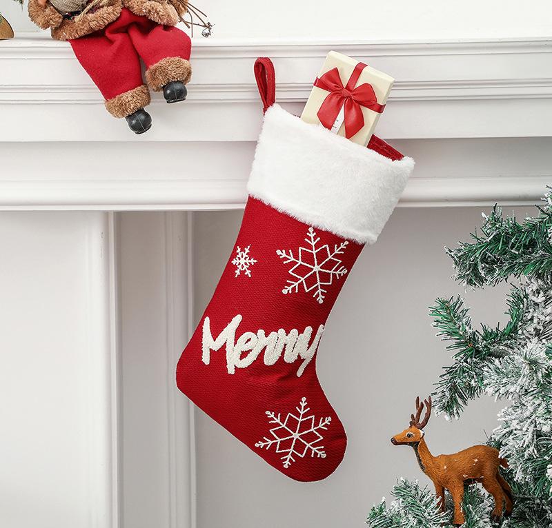 Red Christmas stocking with a white plush cuff, snowflakes and lettering