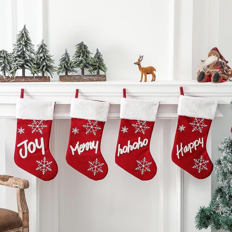 Red Christmas stocking with a white plush cuff, snowflakes and lettering
