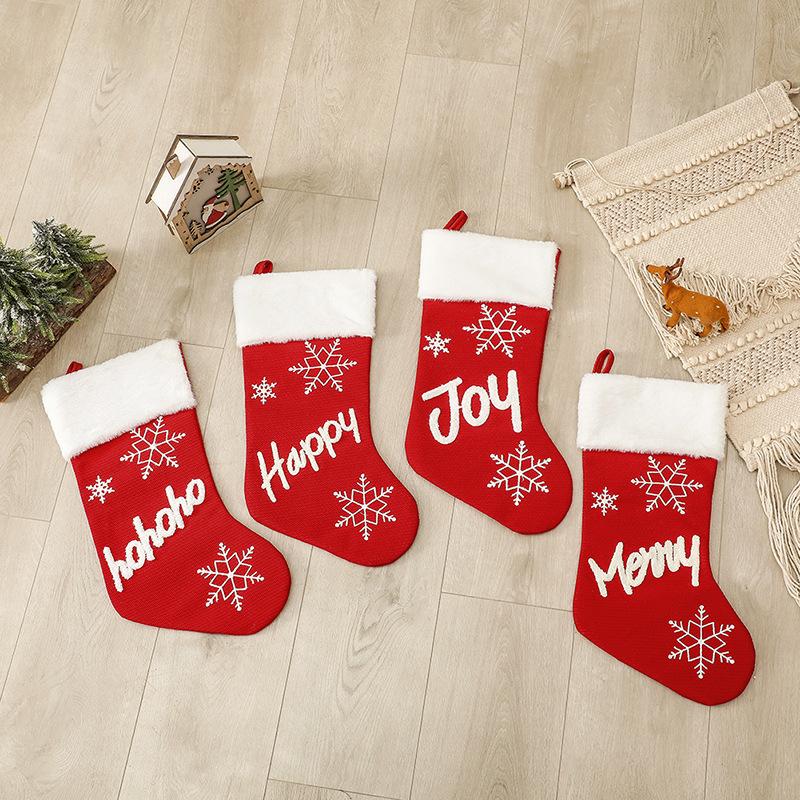 Red Christmas stocking with a white plush cuff, snowflakes and lettering