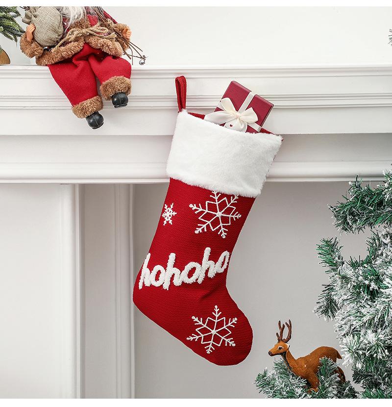 Red Christmas stocking with a white plush cuff, snowflakes and lettering