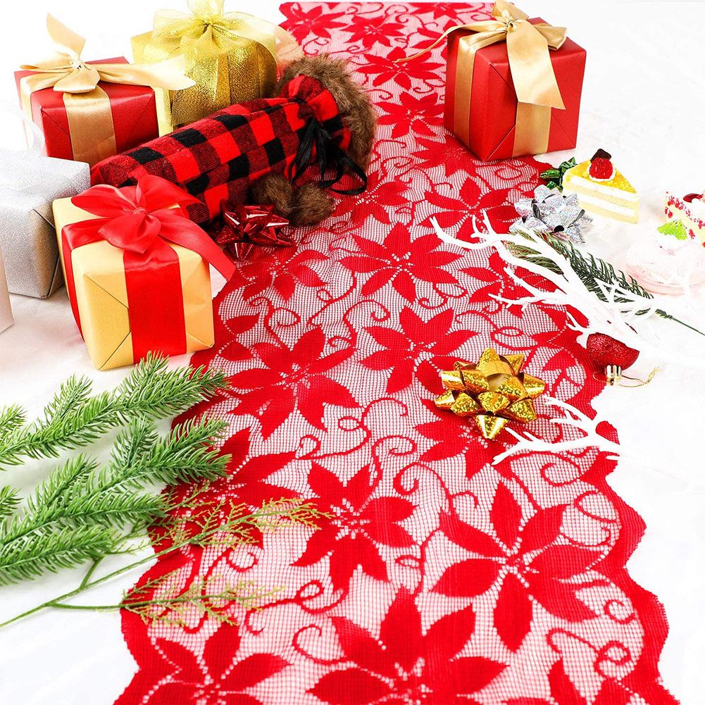Red lace Christmas table runner with poinsettias and a scalloped edge on a table