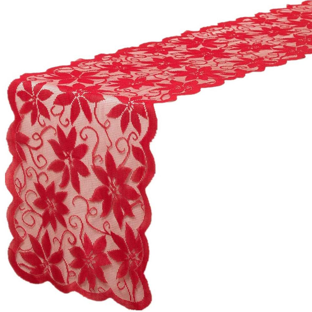 Red lace Christmas table runner with poinsettias and a scalloped edge on a table