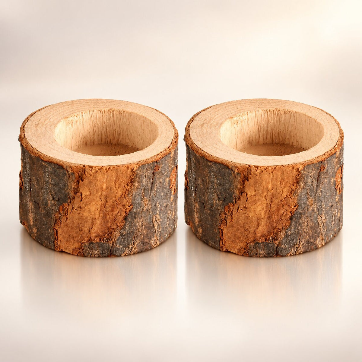 Two rustic wooden tea light holders cut from a log with the bark on