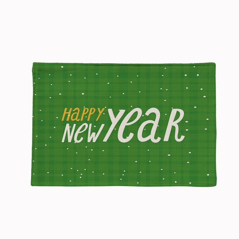 Set of four Christmas placemats with a festive print on a laid table - happy new year on green