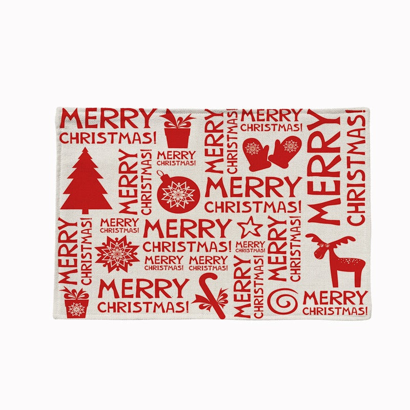 Set of four Christmas placemats with a festive print on a laid table - merry christmas lettering