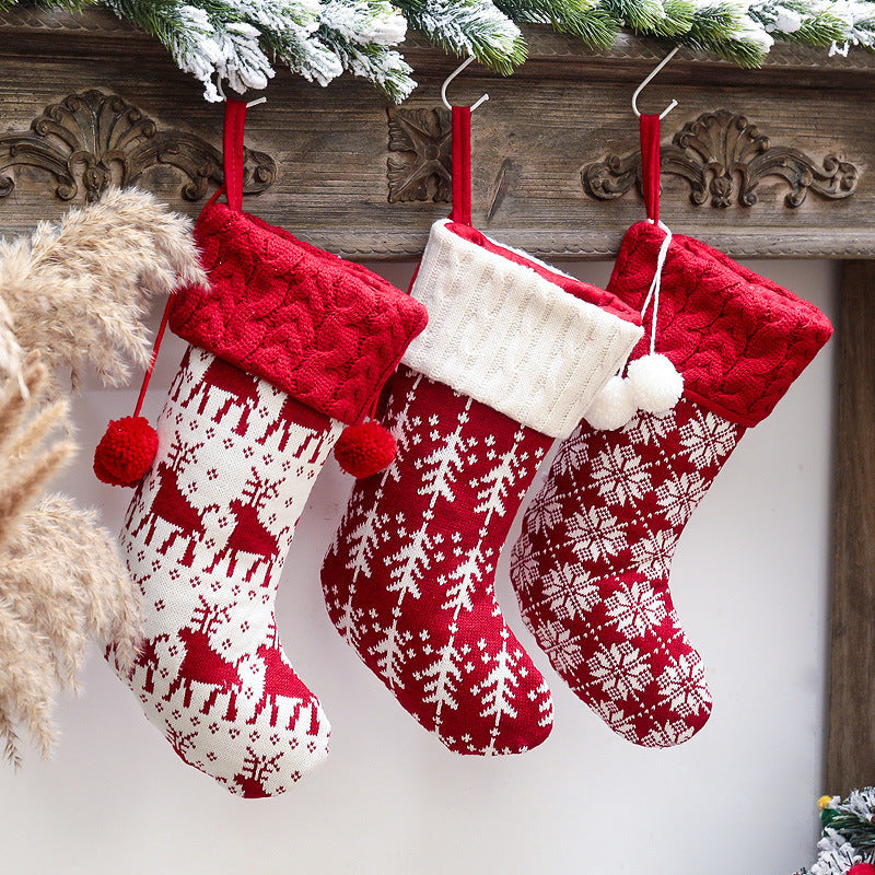 Set of four knitted Christmas stockings with cable cuffs, pompoms and Nordic patterns