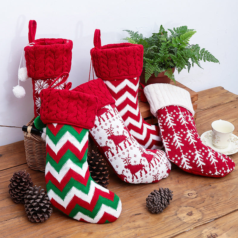 Set of four knitted Christmas stockings with cable cuffs, pompoms and Nordic patterns