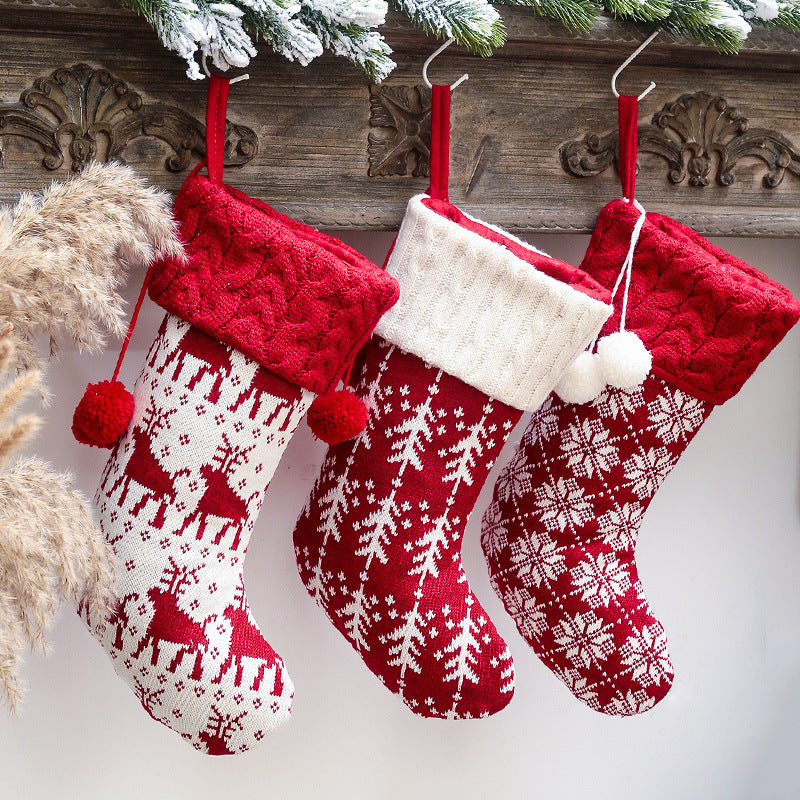 Set of four knitted Christmas stockings with cable cuffs, pompoms and Nordic patterns