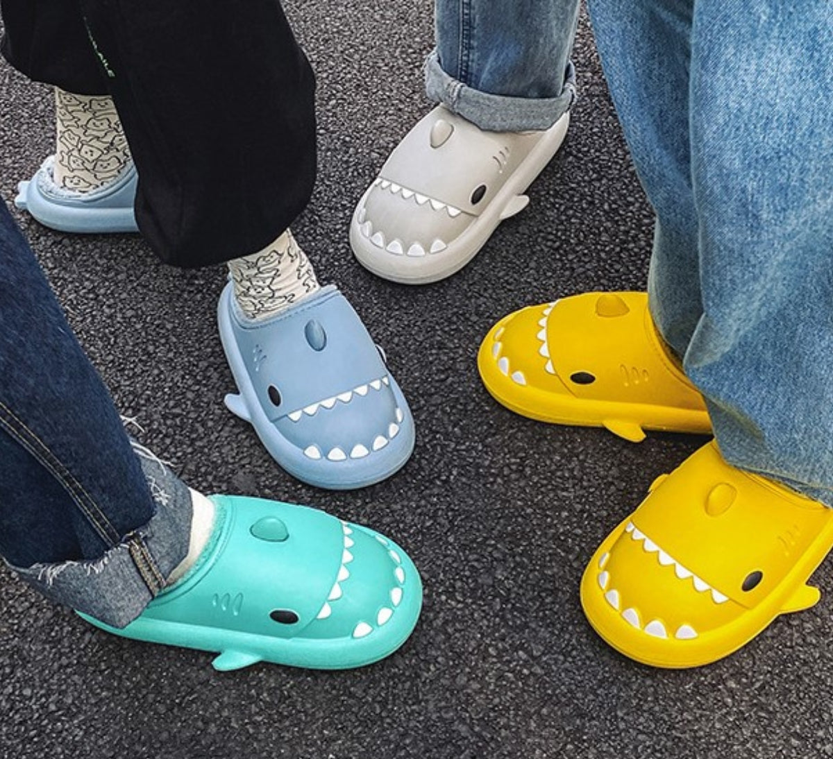 Slippers shaped like a shark's head with teeth, eyes, a fin and plush lining
