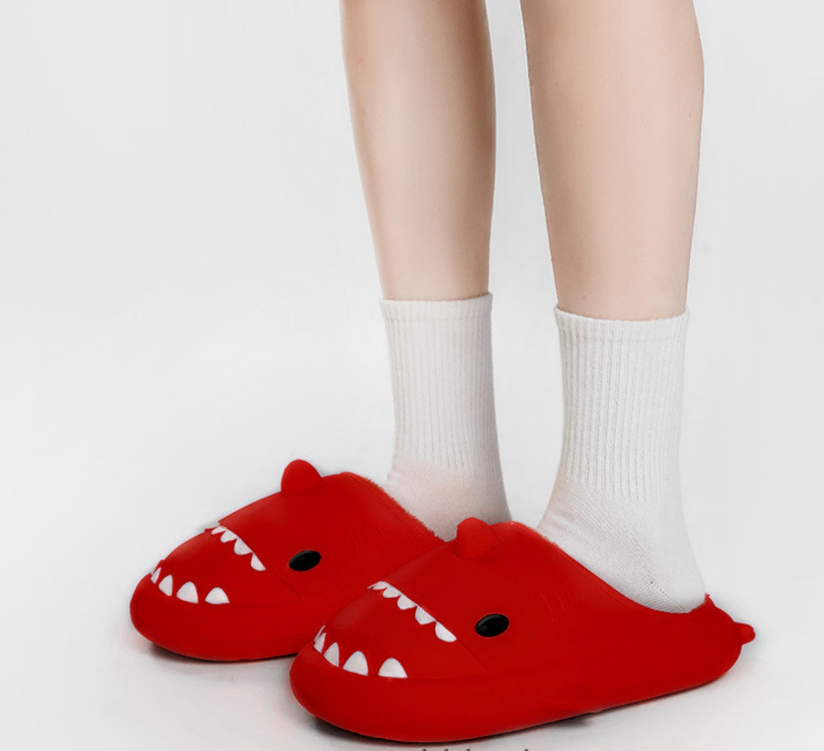 Slippers shaped like a shark's head with teeth, eyes, a fin and plush lining - red