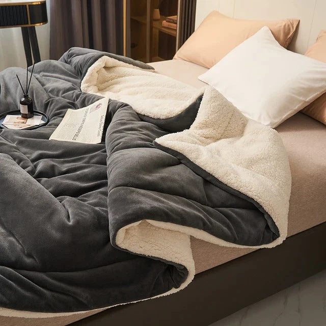 Sherpa blanket with quilted channels on a made bed - charcoal