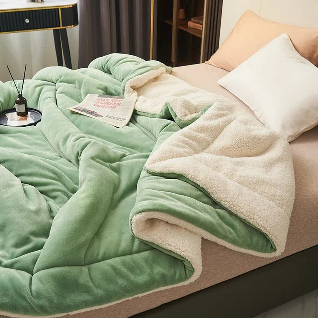 Sherpa blanket with quilted channels on a made bed - light green