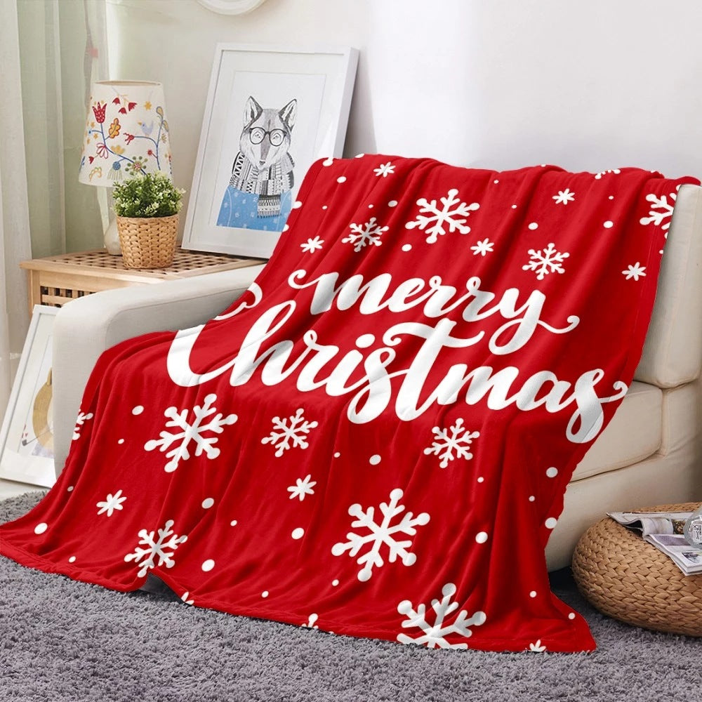 Soft fleece Christmas blanket with an all-over festive print on a sofa