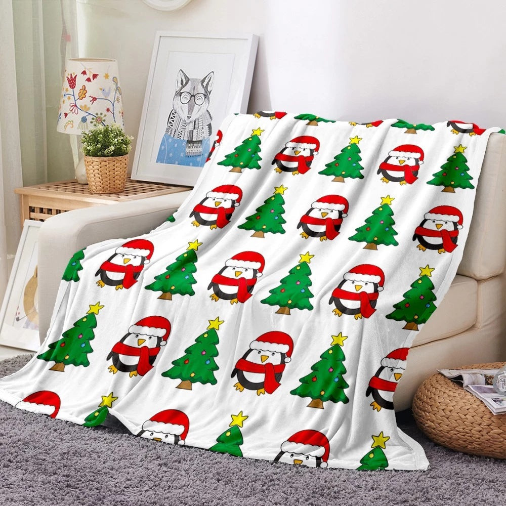 Soft fleece Christmas blanket with an all-over festive print on a sofa - white penguins and trees