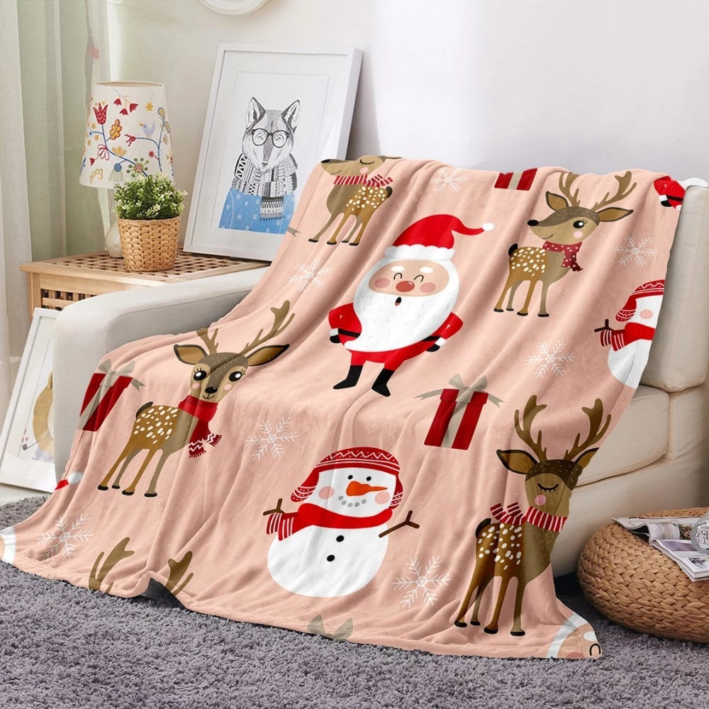 Soft fleece Christmas blanket with an all-over festive print on a sofa - pink santa and reindeer