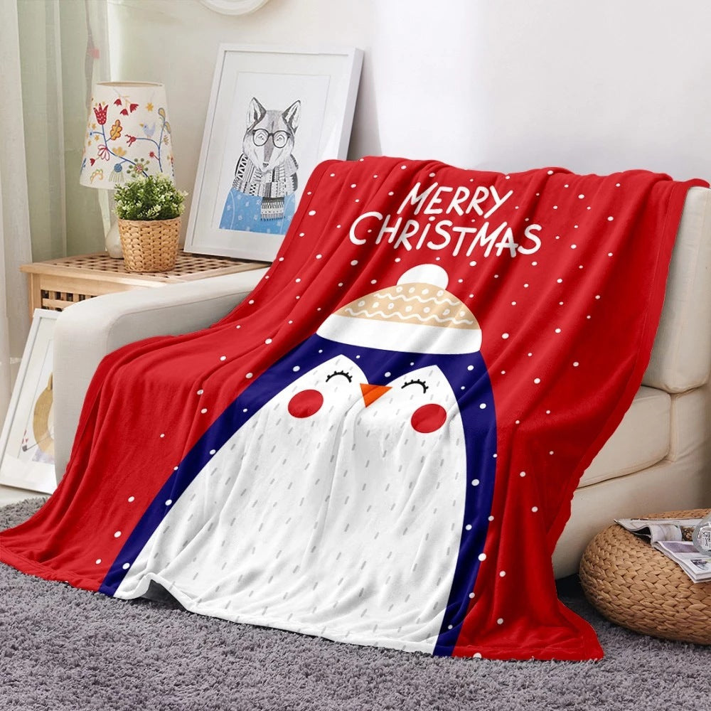 Soft fleece Christmas blanket with an all-over festive print on a sofa - red penguin
