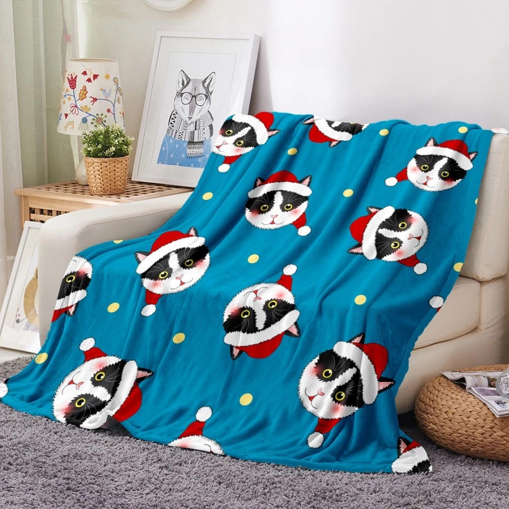 Soft fleece Christmas blanket with an all-over festive print on a sofa - blue cats