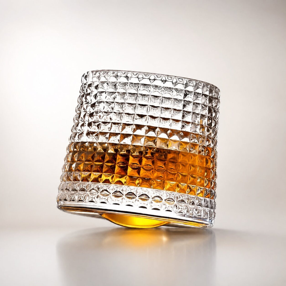 Spinning whisky glass with a rounded base and a wooden coaster - raised squares