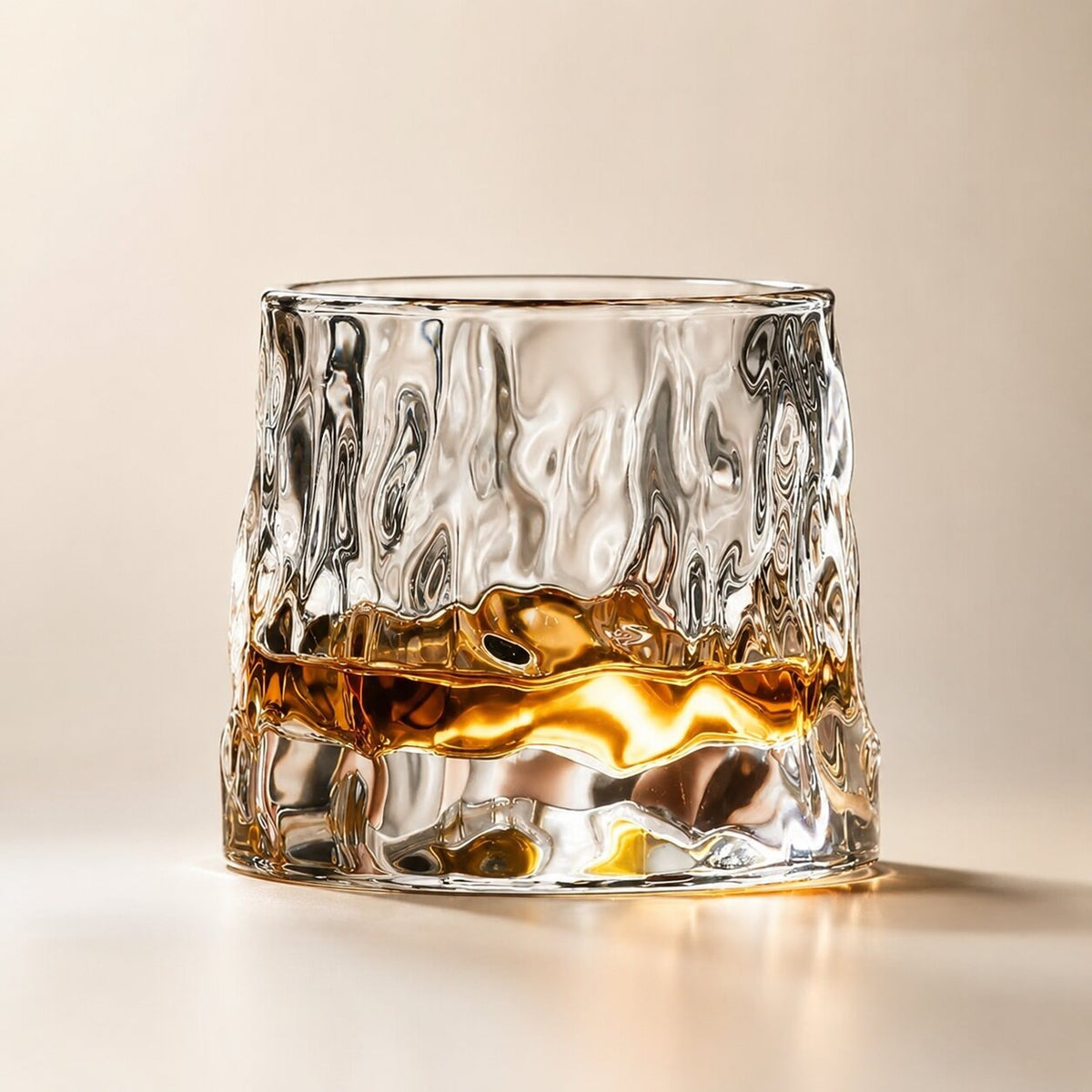 Spinning whisky glass with a rounded base and a wooden coaster - hammered
