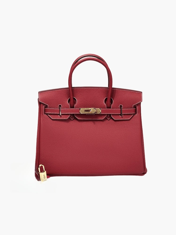 Structured top handle bag with two rolled handles, a flap with turn lock and a padlock - deep red