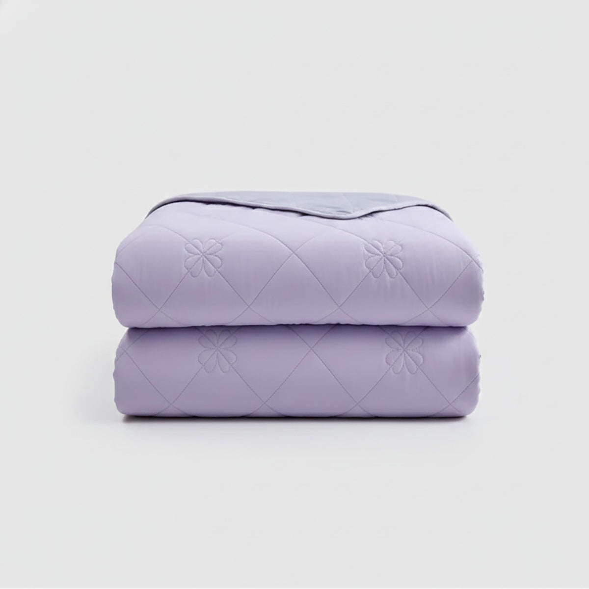 Reversible summer blanket with diamond and floral stitching on a bed - view 2