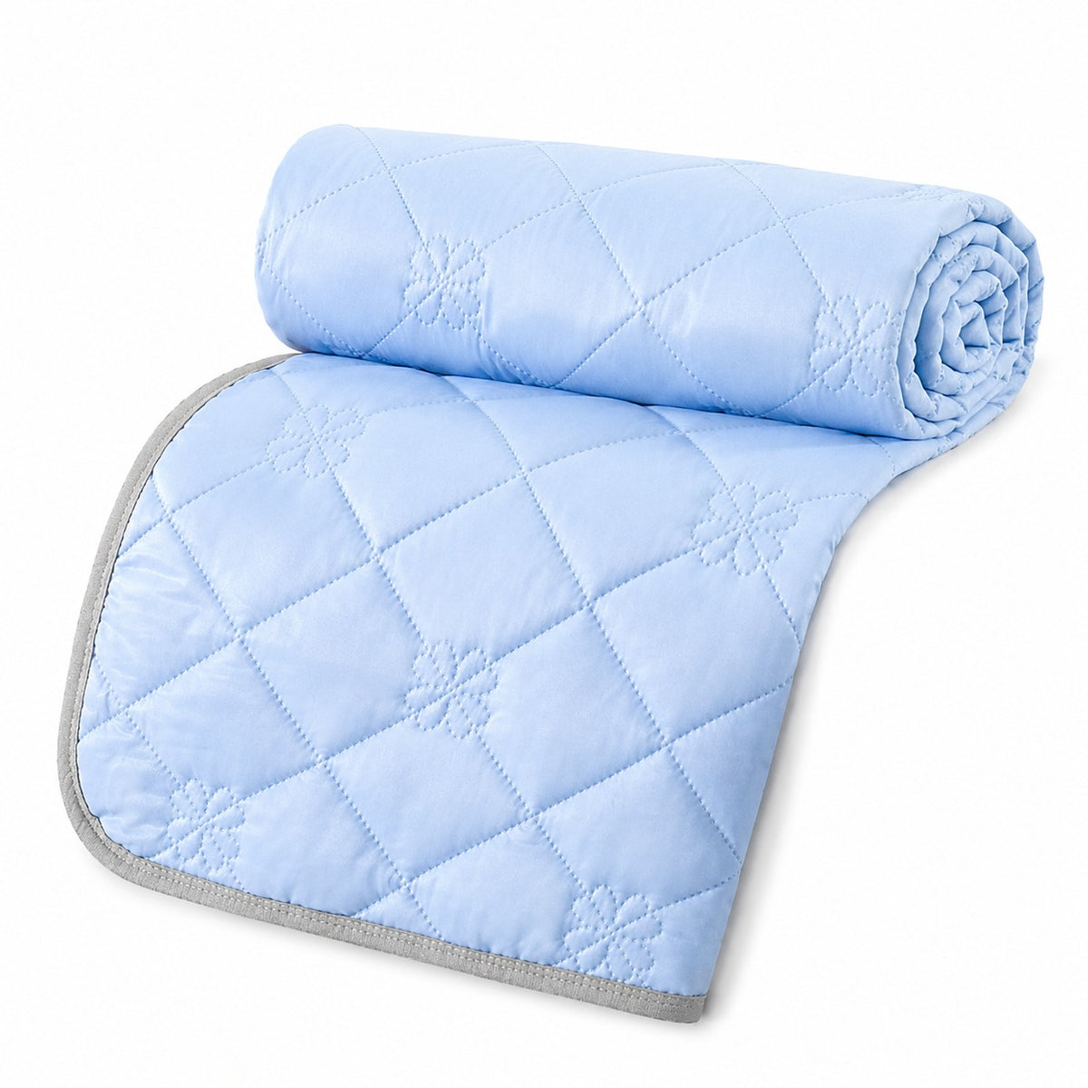 Reversible summer blanket with diamond and floral stitching on a bed - baby blue