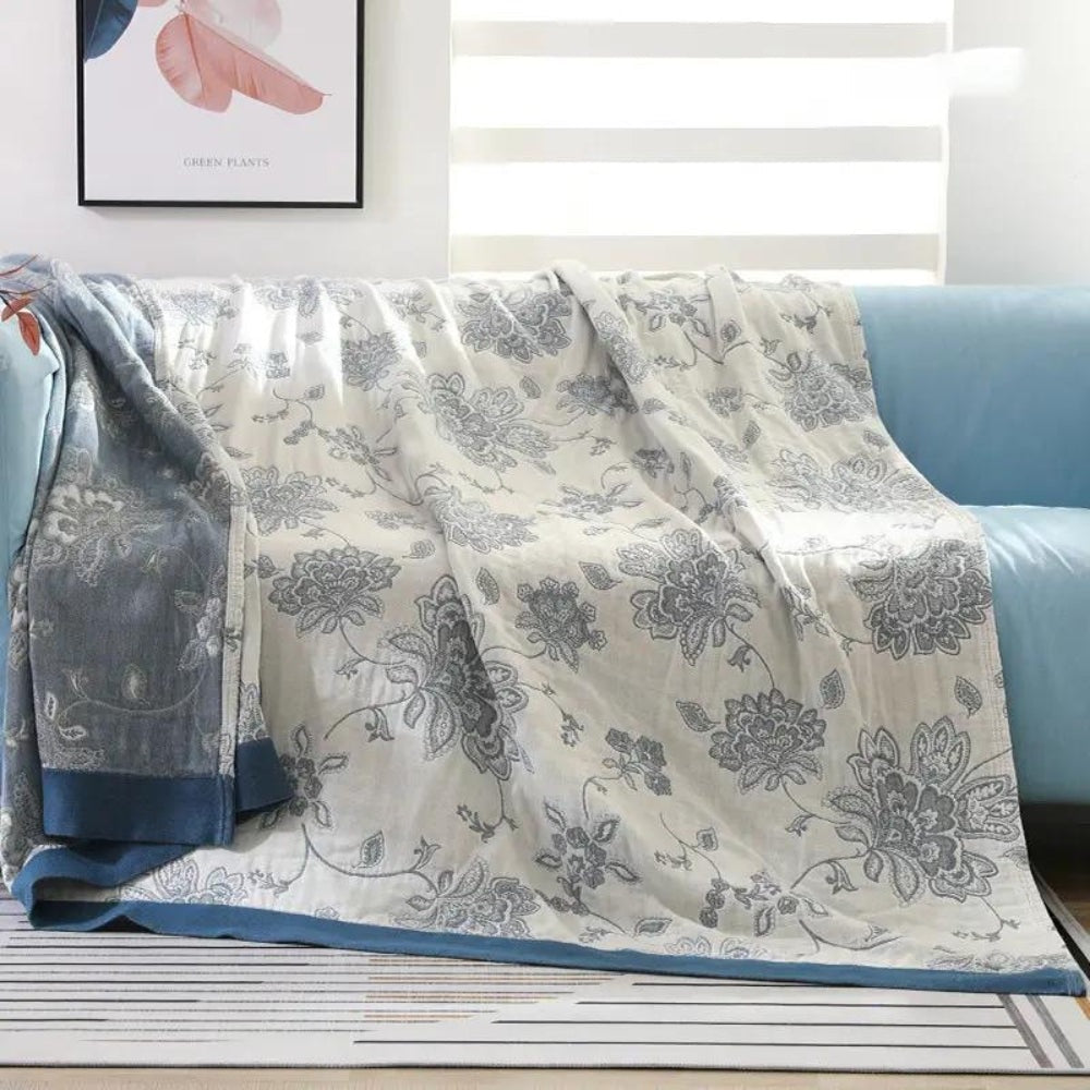 Summer blanket with a jacquard floral pattern over a sofa - cream/blue