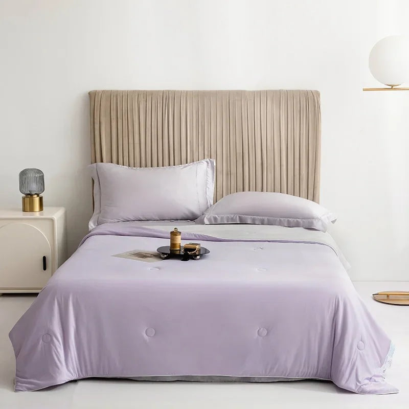 Reversible summer blanket with a grey underside on a double bed - lilac