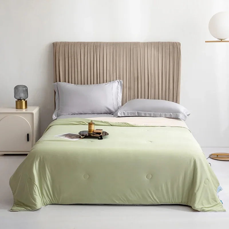 Reversible summer blanket with a grey underside on a double bed - pistachio green