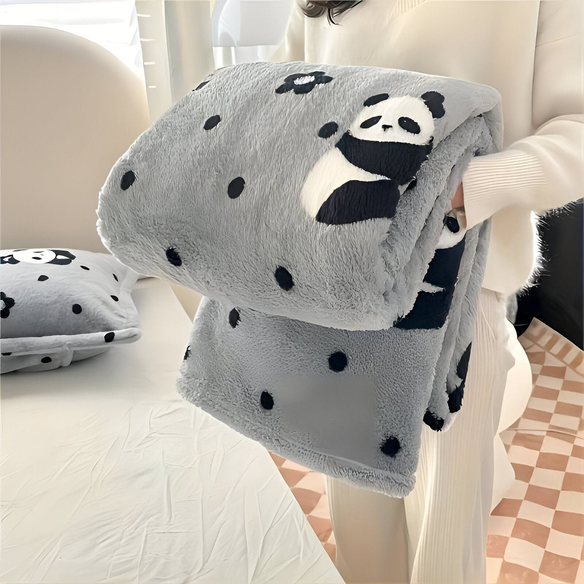 Teddy fleece blanket with a checkerboard pattern, folded in someone's arms - grey with pandas