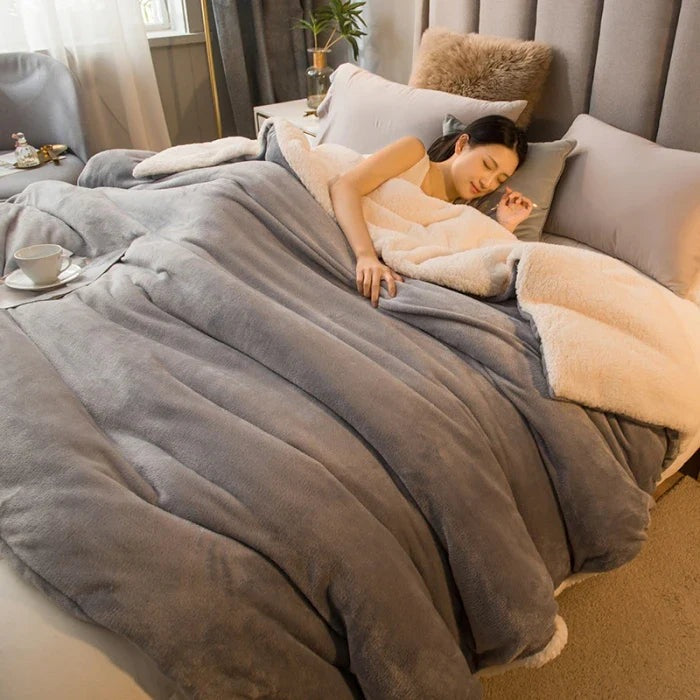 Thick sherpa blanket with a velvet-soft side on a bed - silver grey