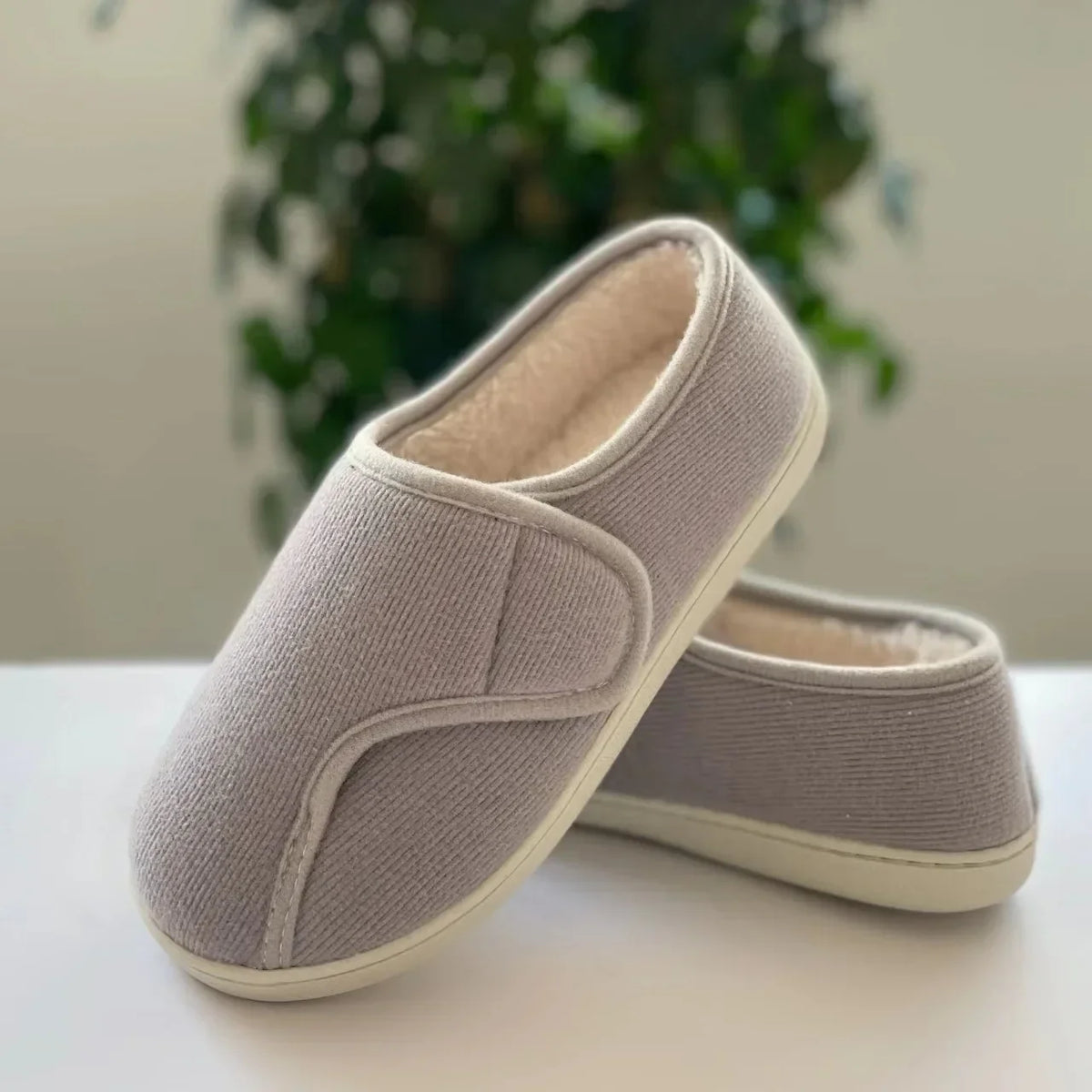 Extra-wide unisex slippers with an adjustable strap and a plush lining