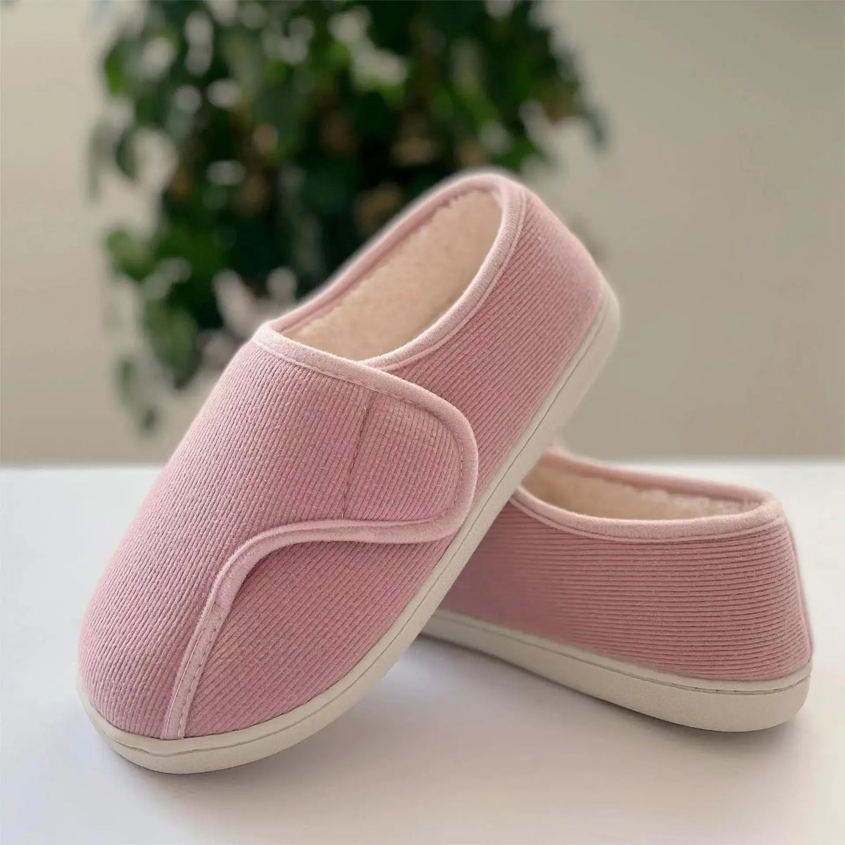 Extra-wide unisex slippers with an adjustable strap and a plush lining