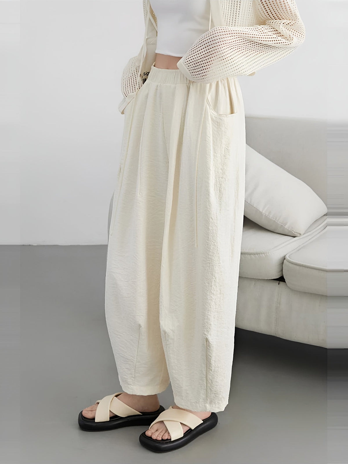 Women's cream wide-leg trousers from the side, showing the curved leg