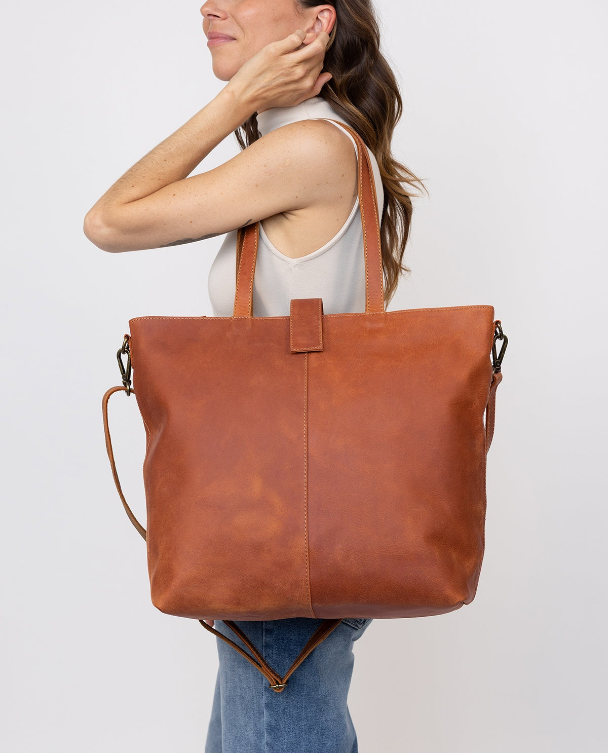 Women's brown leather tote bag with short handles and a detachable shoulder strap