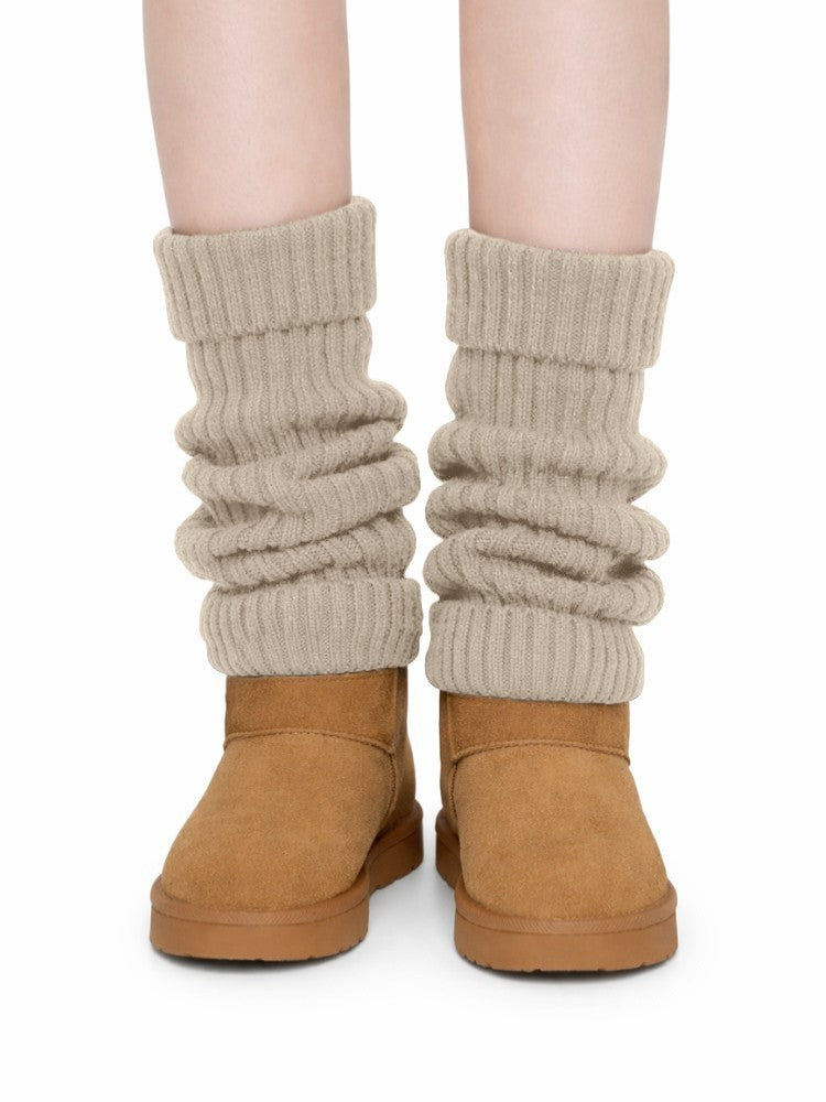Women's ribbed knit leg warmers with a fold-over cuff, worn over boots - beige
