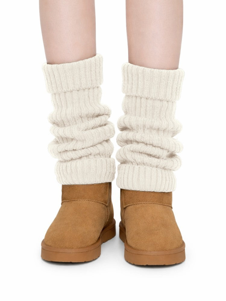 Women's ribbed knit leg warmers with a fold-over cuff, worn over boots - cream