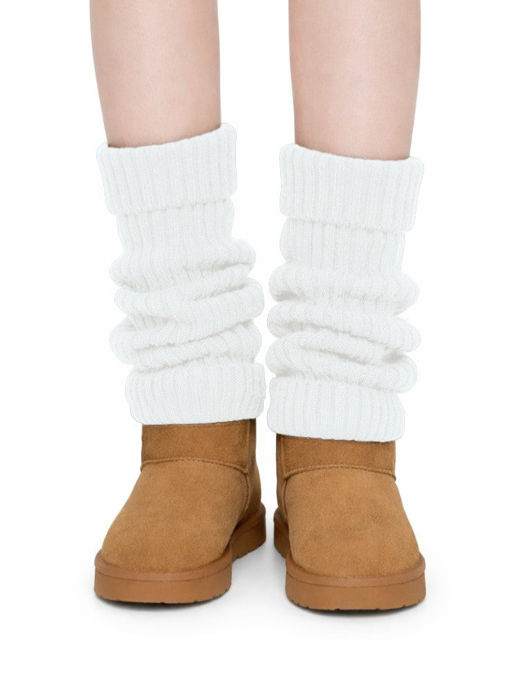 Women's ribbed knit leg warmers with a fold-over cuff, worn over boots - white