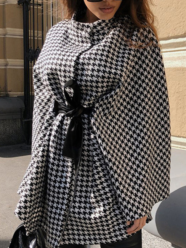 Black and white houndstooth cape coat with a stand collar and tie belt